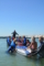 Gruppe mit SUP-Board auf dem ein Mädchen turnt, während die Anderen das Board stützen